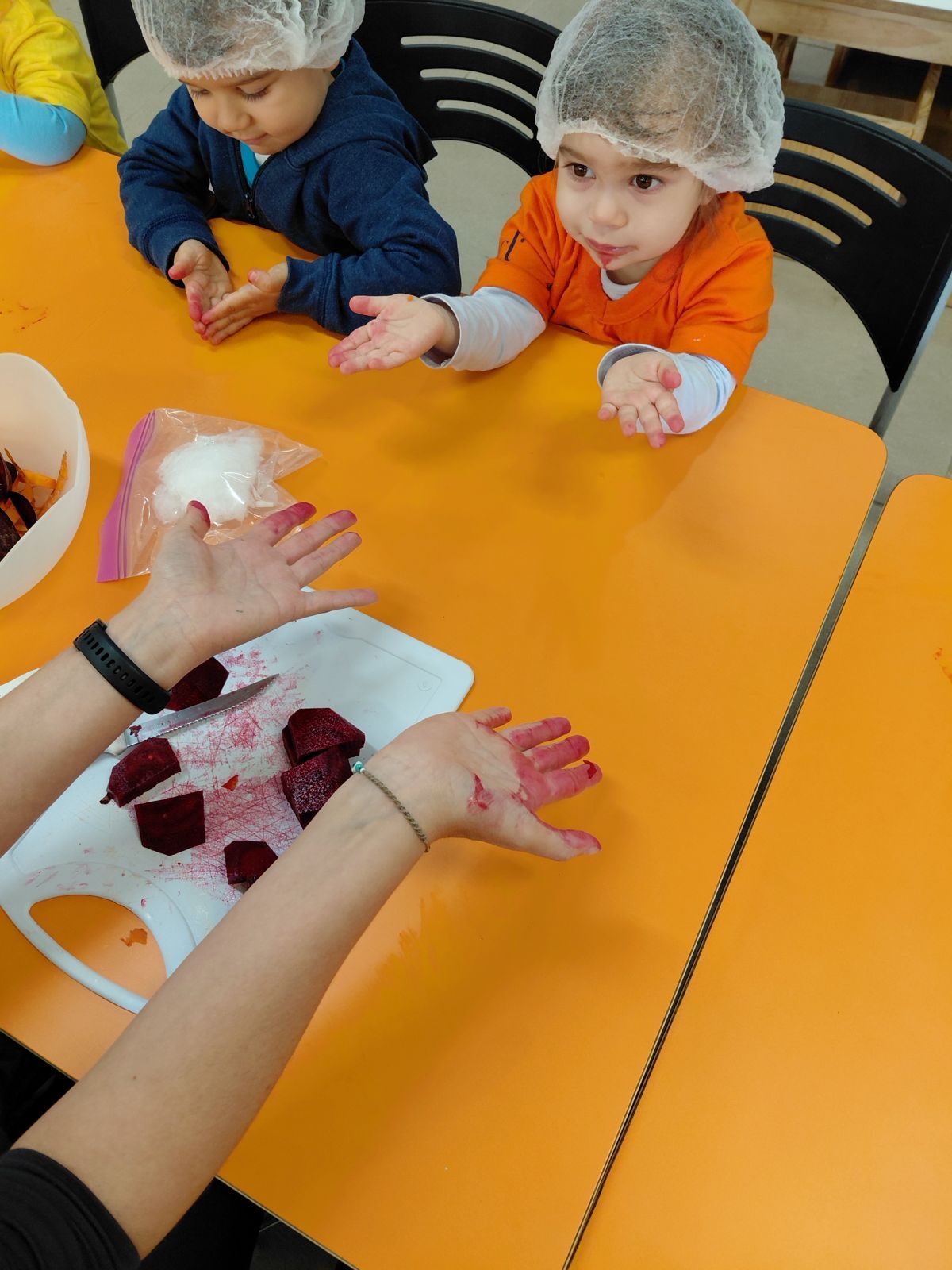 Crianças em atividade de culinária com beterraba
